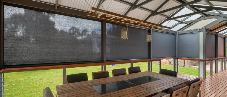 Mesh outdoor blinds enclosing a covered outdoor dining area